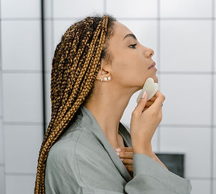 Woman doing facial gua sha on herself