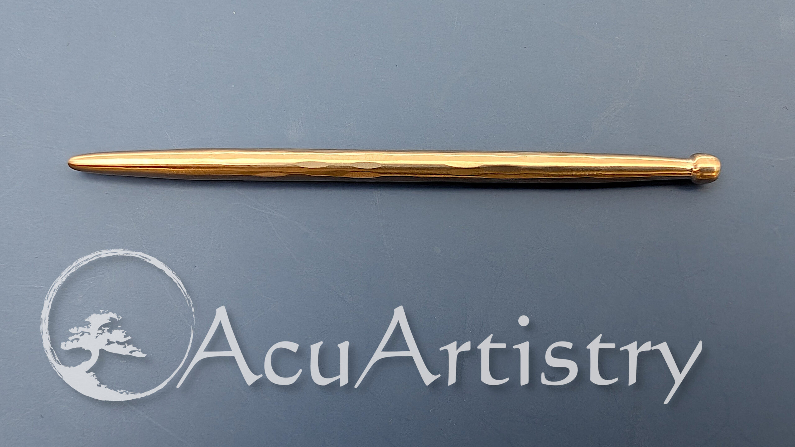 Side view of a Bronze teishn with a blue grey background